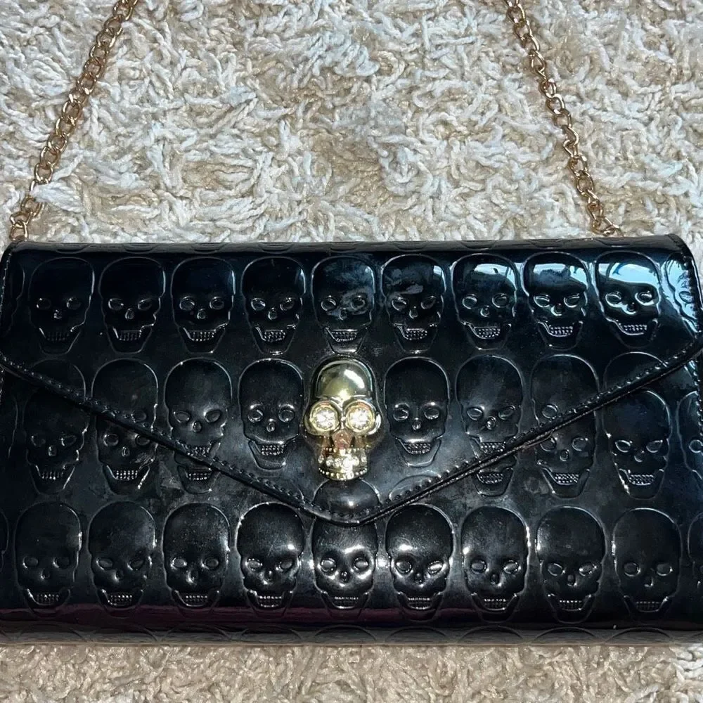 Awesome patent leather skull embossed clutch bag with gold chain shoulder strap.